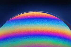 Macro Closeup of a Soap Bubble on a Dark Blue Background photo