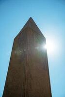 Egyptian Ancient Abelisk Peak with Sun Glare in Background photo