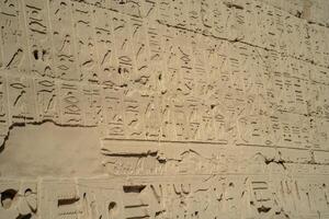 Ancient Egyptian ancient wall with carved hieroglyphs in Luxor photo