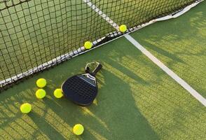 Background of padel racket and ball on artificial grass floor in outdoor court. Top view. photo