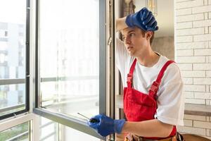 Worker installing plastic window indoors, closeup view photo