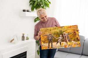 Canvas print with gallery wrap. woman hangs autumn photography, photocanvas photo