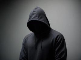 Mysterious figure in a hooded sweatshirt with an obscured face. photo