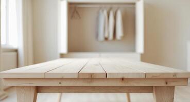 An empty wooden table with a blurred closet in background provides a perfect setting for displaying or showcasing your products in a room photo