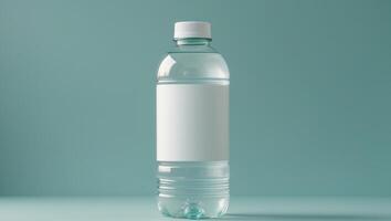 Clear plastic water bottle with blank label on teal background photo