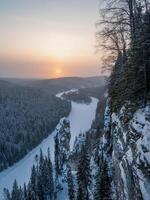 Amazing winter mountains landscape with trees and rocks at sunrise photo