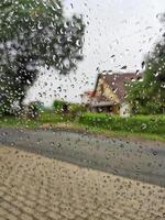 Rainy day, wet glass with raindrops, a look through wet glass. photo
