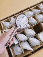 Man's hand holds the watering can from the shower photo