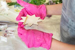 Art process of pouring epoxy resin into a wooden toy. Technology process of creating a painting in style resin art, works with epoxy in studio, makes a wooden stand photo
