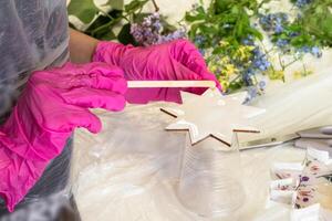 Art process of pouring epoxy resin into a wooden toy. Technology process of creating a painting in style resin art, works with epoxy in studio, makes a wooden stand. photo