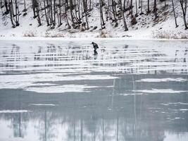 Dangerous exit to the spring thin ice. A man walks on thin ice. Forbidden access to the ice in the spring. photo