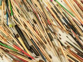 Old paint brushes are scattered on the table. The artist's mess. Drawing tools top view, copy space, close-up. photo