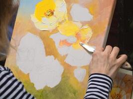 Drawing texture paste, working with a spatula, creating a three-dimensional drawing of flowers. photo