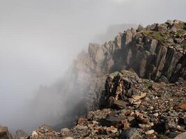 Foggy mountain view from cliff at very high altitude photo