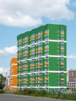 Colored wall on the background of blue sky. Modern construction, new neighborhood. Copy space. photo