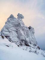 Big snow rock is frozen and covered with snow photo