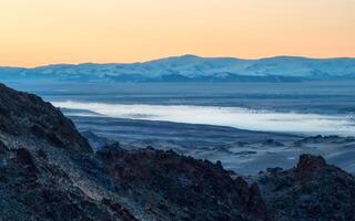 Valley with the river in the distance is covered with fog. photo