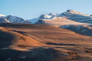 snowy mountain ridge illuminated by setting sun photo