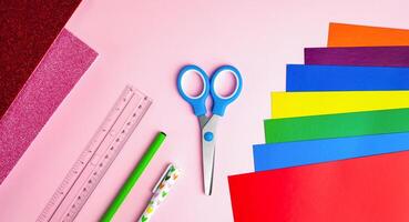 Set of color papers, scissors, ruler, pen and pencil for Valentine's day card crafts on pink background. Top view. Flatlay. Paper craft projects. photo