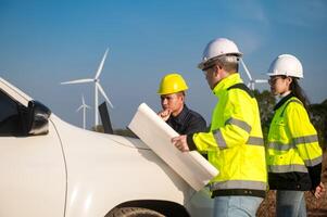 Engineers brainstorm on a plan to inspect the performance of wind turbines photo