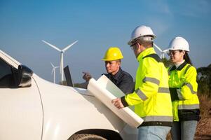 Engineers brainstorm on a plan to inspect the performance of wind turbines in the area photo