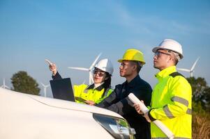 Engineers brainstorm on a plan to inspect the performance of wind turbines in the field using a pickup truck photo