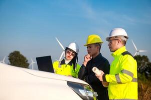 Engineers brainstorm on a plan to inspect the performance of wind turbine in the area photo