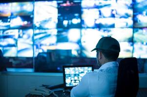 Security guards are monitoring multiple CCTV monitors and reporting on events that occur.. photo