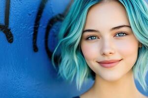 Artistic portrayal of a girl with teal hair embracing the beauty of evening light in front of a striking navy-blue graffiti wall photo
