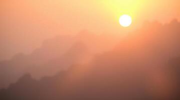 A blurry image of a mountain range with the sun setting photo