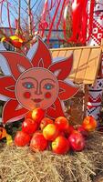 Vibrant autumn harvest display with sun motif and red apples photo