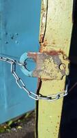 Rusty metal chain securely fastened on weathered surface photo