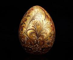 Intricate golden egg decorated with elegant floral patterns on a dark background photo