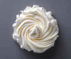Delicate swirl of whipped cream displayed on a neutral background for culinary delight photo