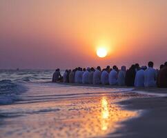 Gathering of individuals on the beach at sunset enjoying the serene view over the water photo