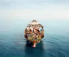 Large cargo ship navigating through calm waters with stacked containers under clear sky photo