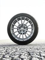 High-quality car wheel positioned on textured asphalt surface against a bright background photo