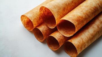 Amber craft paper rolls arranged elegantly on a smooth surface await creative use photo