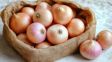 Fresh onions collected in a burlap sack on a rustic wooden table photo