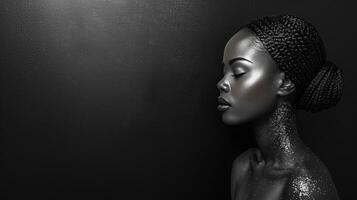 A woman with silver body paint and braids poses against a dark background photo