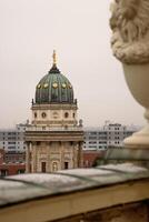Rooftop view of the New German Cathedral golden adorned Dome in Berlin from the French Church terrace, showing contrast between historical and modern architecture, Foggy cloudy day. Copy space 8 photo