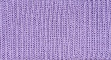 Knitted fabric made of purple wool threads, pigtail pattern photo