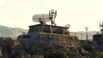 A military base with a rock structure and a satellite dish on top video