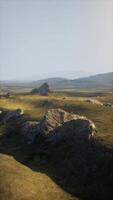 Grassy Field With Rocks and Mountains video