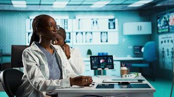 General practitioner uses a stethoscope to consult patient with illness, ensuring normal function of lungs and heartbeat. African american girl with a respiratory problem at checkup. Camera B. video