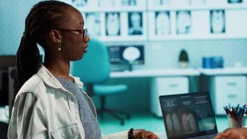 Professional medic hosts a consultation with young patient in the clinic, doctor does x ray imaging interpretation for a girl at routine checkup. Fostering health care trust and accuracy. Camera A. video