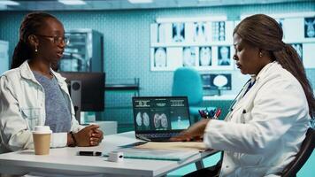 Professional medic hosts a consultation with young patient in the clinic, doctor does x ray imaging interpretation for a girl at routine checkup. Fostering health care trust and accuracy. Camera B. video