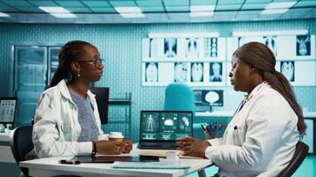 Health specialist measuring the oxygen saturation and pulse rate using oximeter during routine checkup, consult a black girl patient with modern medical tools. Vital signs measurement. Camera B. video