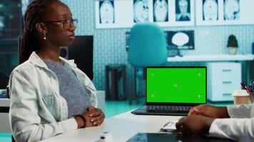 Doctor and patient discuss about health care recovery next to mockup screen, meeting in cabinet to share advice and medicine. Professional medic consulting girl during routine checkup. Camera A. video
