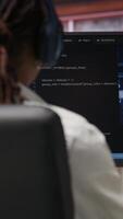 Vertical IT engineer drinking coffee, using computer at home for artificial intelligence computing. Close up of remote worker working with AI deep neural networks on desktop PC, camera B video